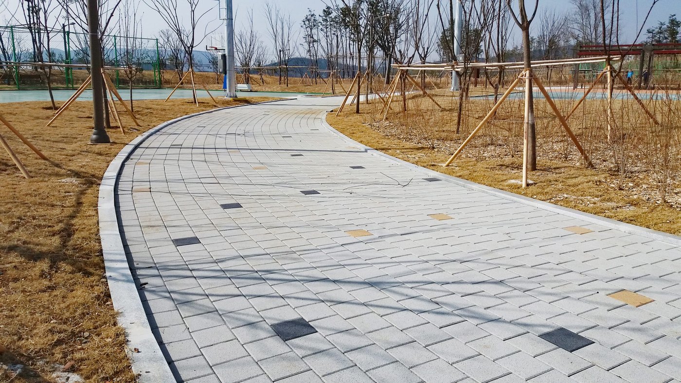 완만하게 휘어지며 이어지는 보도블록 산책로